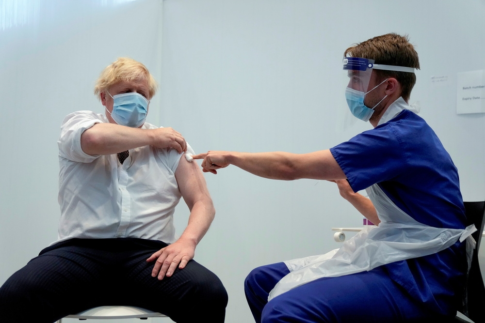 英國首相強森（左）率先接種疫苗。（湯森路透）