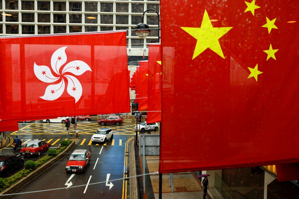 美國科技公司揚言要退出香港，圖為中共百年黨慶當天，香港街頭掛起中港旗幟景象。（湯森路透）