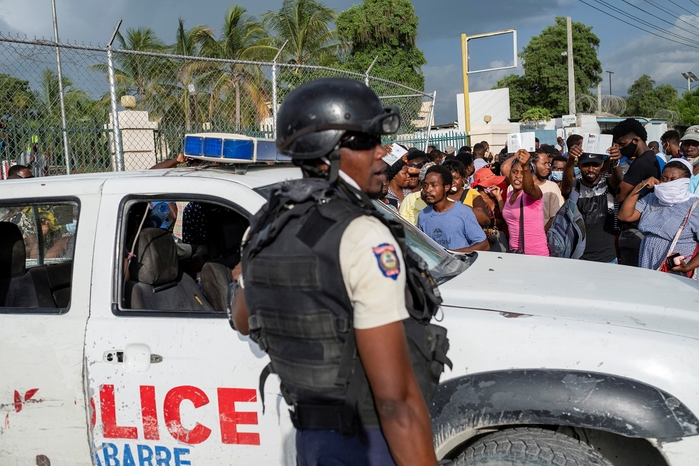 海地總統暗殺案發生後，許多民眾前往美國駐海地大使館尋求庇護，警方在外頭維持秩序。（湯森路透）
