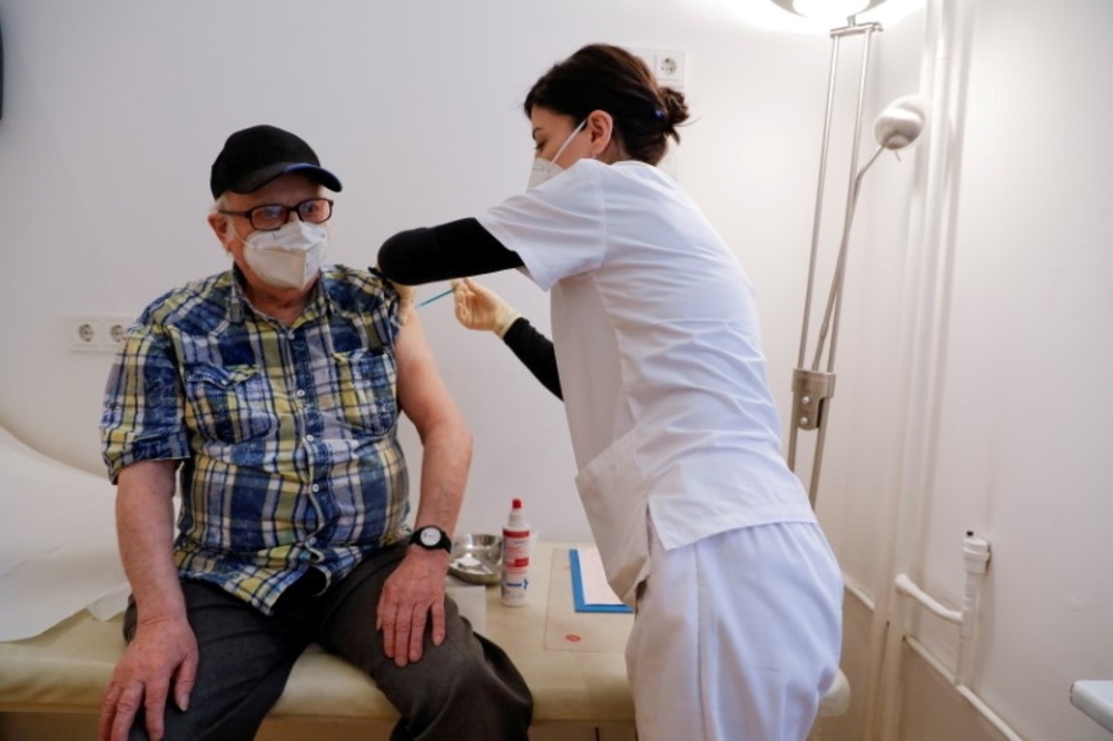 德國醫護人員替民眾施打新冠疫苗。（湯森路透）