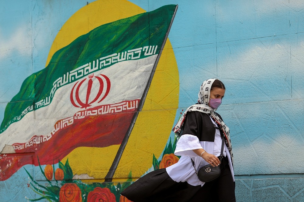 伊朗疫情相當嚴峻，民眾出門戴上口罩以避免染疫。（湯森路透）