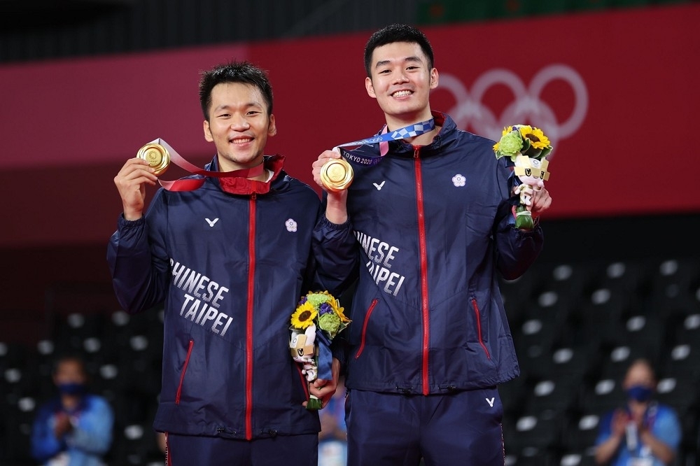 李洋（左）、王齊麟以絕佳默契奪下東奧羽球男雙金牌。（中華奧會提供）