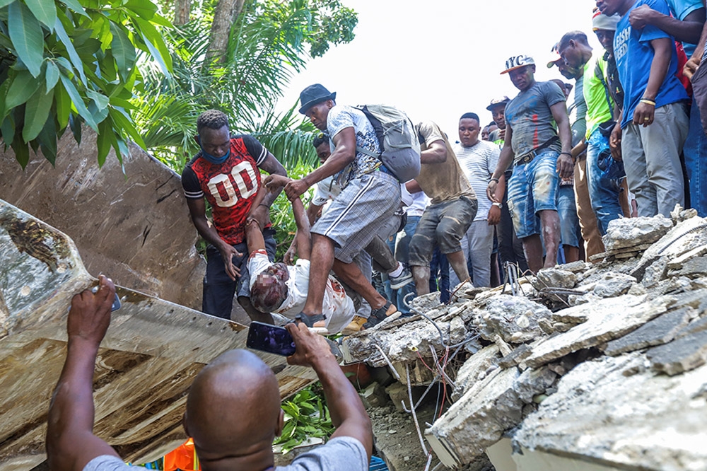 海地14日晚間發生7.2強震，不少居民受困瓦礫堆中，救災人員正積極搶救。（湯森路透）