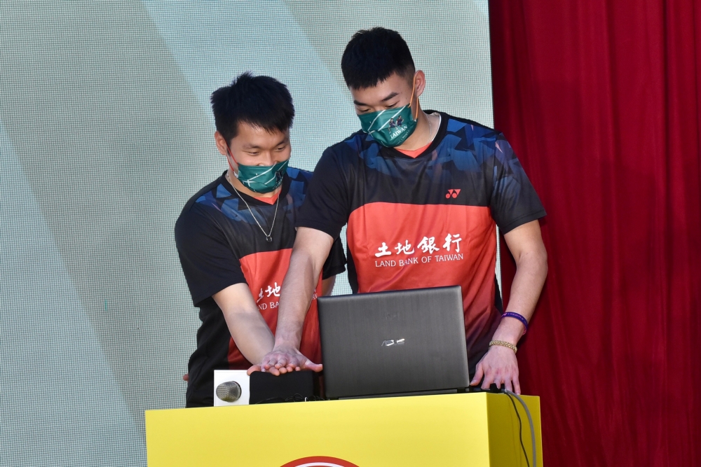 東奧羽球金牌男雙李洋（左）與王齊麟返台結束隔離後首合體，19日出席台灣運彩活動，兩人手心交疊按抽獎鈕。（張哲偉攝）
