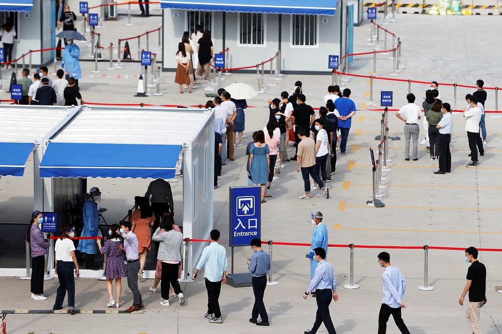 上海浦東機場的員工排隊進行採檢。（湯森路透）