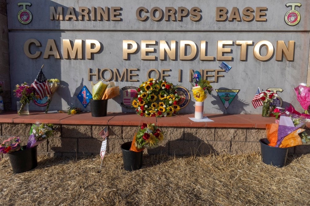 喀布爾機場爆炸案發生後，許多鮮花被放在加州的彭德頓營海軍陸戰隊基地大門。（湯森路透）