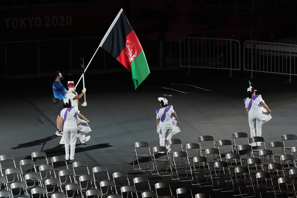 東京帕運開幕式中，志工舉著阿富汗國旗。（湯森路透）