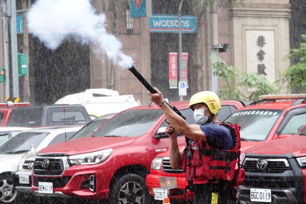 新北事長侯友宜12日上午前往板橋區海山消防分隊及新海派出所視察。圖為救難人員示範CO2拋繩槍。（王侑聖攝）
