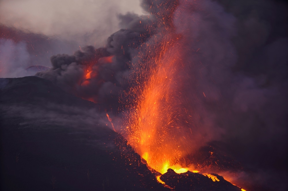 老峰火山２日再度激烈活動，滾燙的岩漿染紅夜晚。（湯森路透）