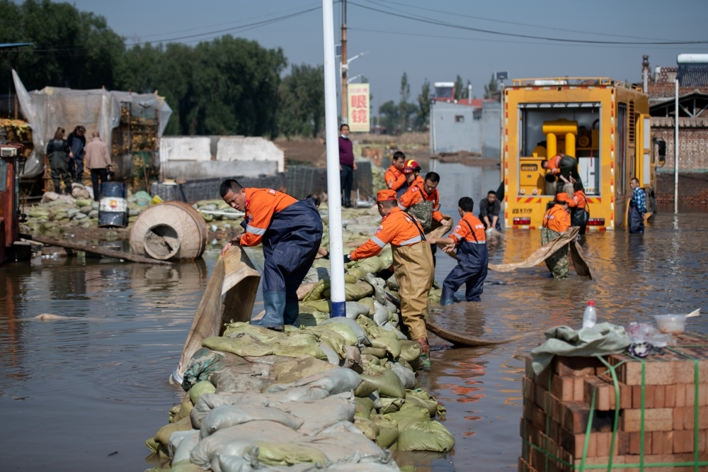 陝西的嚴重洪災導致農作物被淹，人員急著搶救。（湯森路透）