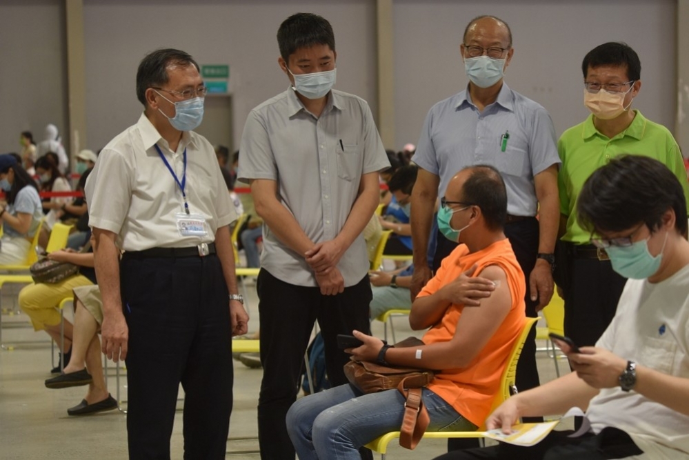 第12輪疫苗預約18日上午10點一開放不到1小時全數額滿，引發民怨，台北市副市長蔡炳坤（左1）怒轟中央不負責。（資料照片／蔣銀珊攝）