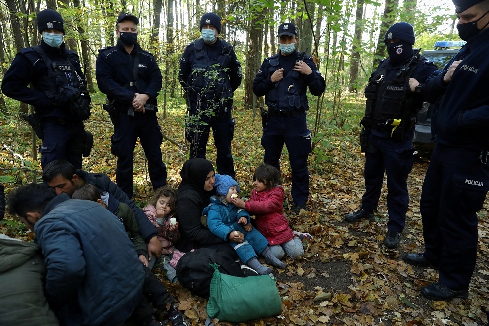 伊拉克難民進入波蘭境內，被警方團團包圍。（湯森路透）