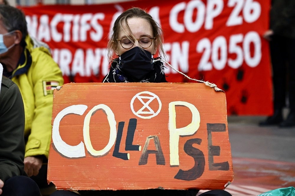 聯合國氣候變化綱要公約第26次締約方會議（COP26）在蘇格蘭格拉斯哥（Glasgow）舉行，環保人士舉牌抗議。（湯森路透）