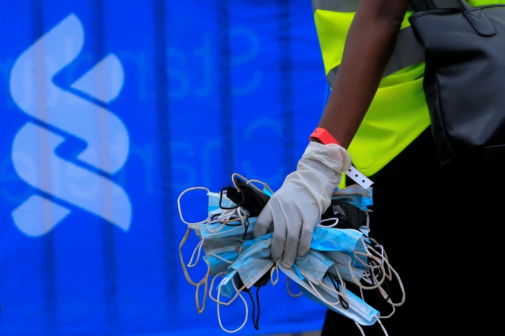 2021年舉辦於奈洛比的馬拉松大賽、工作人員拾起眾多廢棄口罩。（湯森路透）