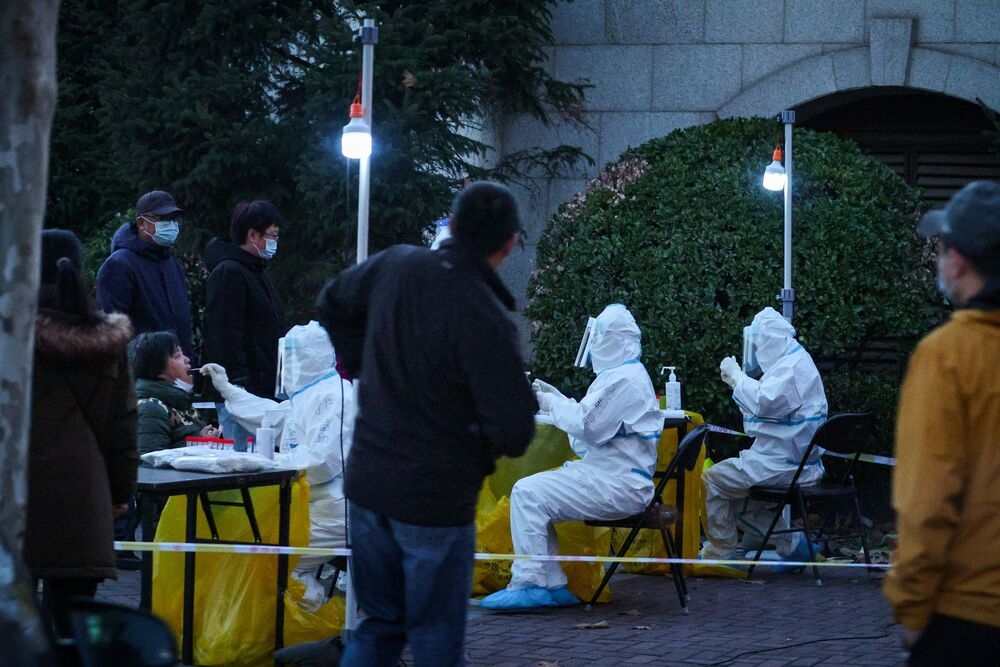 北京防疫人員對社區居民進行集體篩檢。（湯森路透）