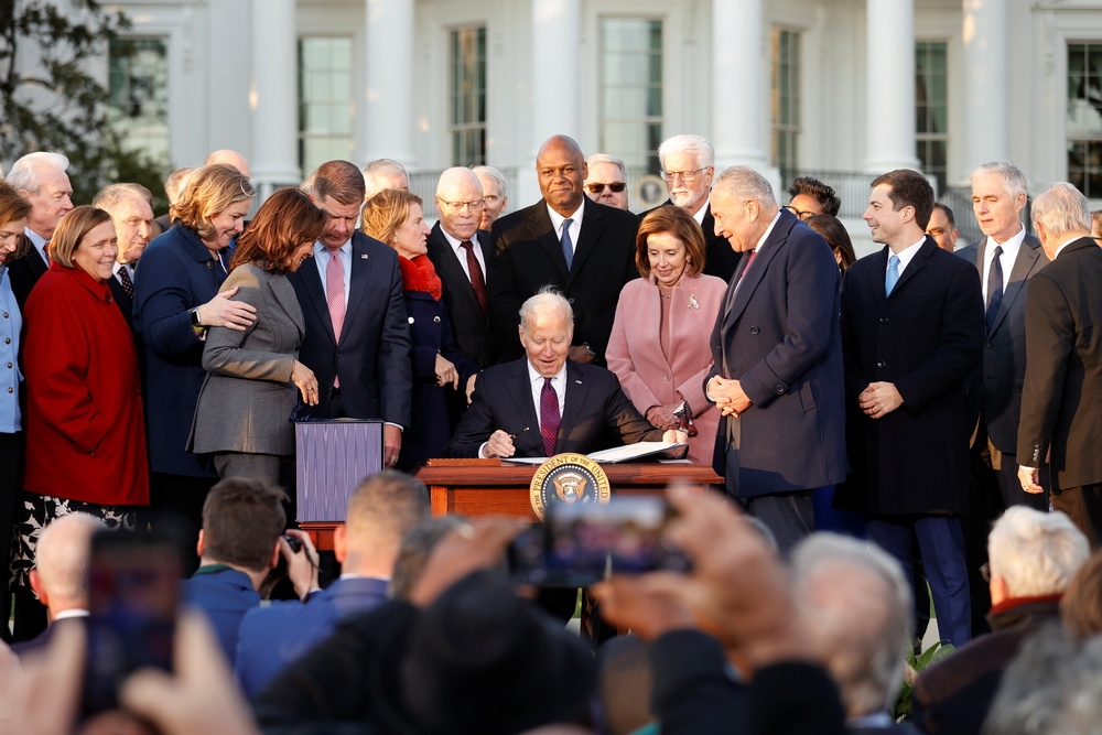 民主、共和兩黨議員見證下，美國總統拜登在白宮簽署1.2兆美元基建法案。（湯森路透）