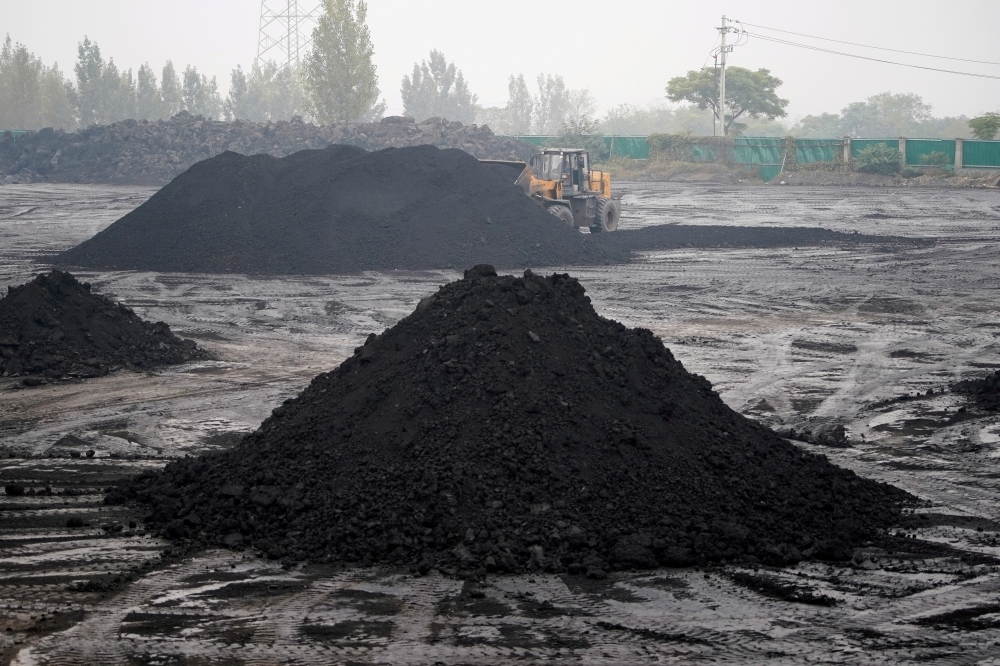 一台挖掘機在中國河南平頂山煤礦附近，對低品質煤進行篩選。（湯森路透）