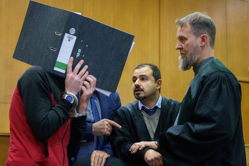 用書夾遮住面部的犯人塔哈，1日被德國法院以「種族滅絕罪」判處無期徒刑。（湯森路透）