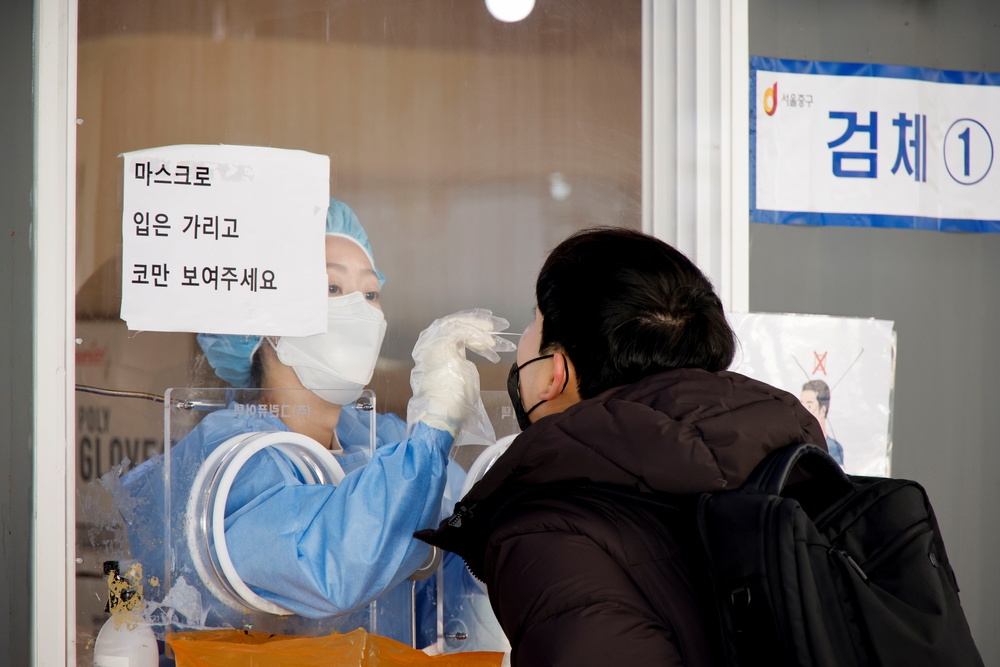 南韓醫護人員替民眾進行核酸篩檢。（湯森路透）