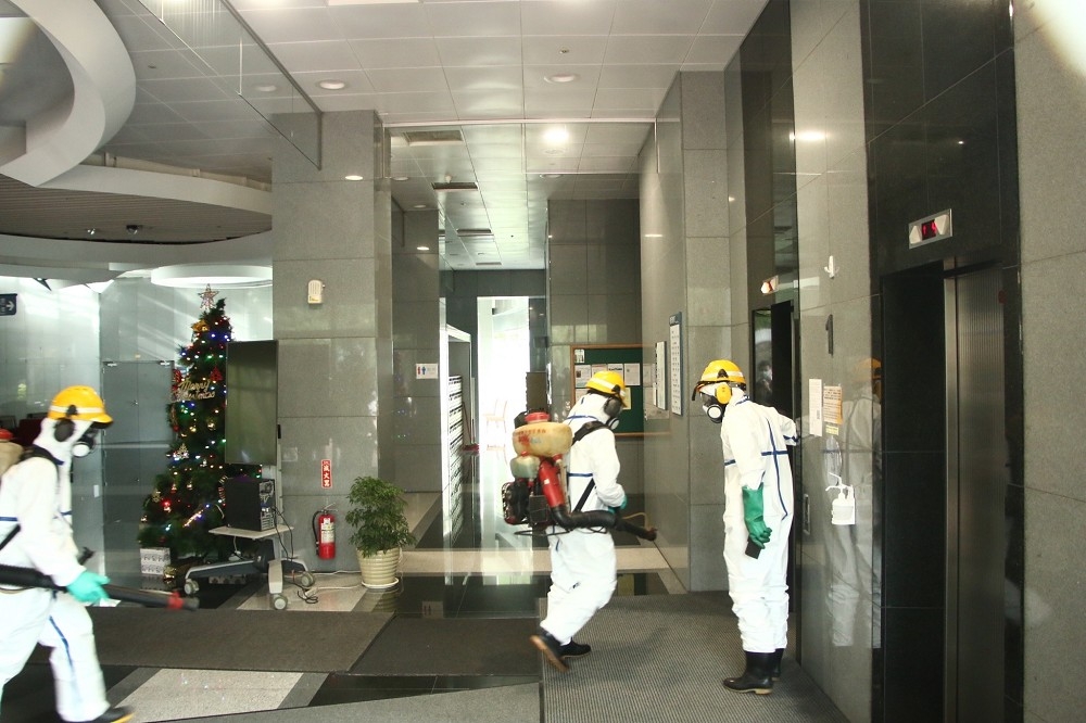 台北市環保局10日派出消毒人員進入基因體研究中心內部進行消毒。（王侑聖攝）
