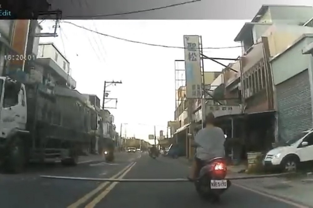 中壢一名騎著機車的阿嬤，在踏板上橫放了一根超長鐵棍，大搖大擺行駛在路上，影響用路人安全。（擷自WoWtchout - 地圖型行車影像分享平台 YouTube）