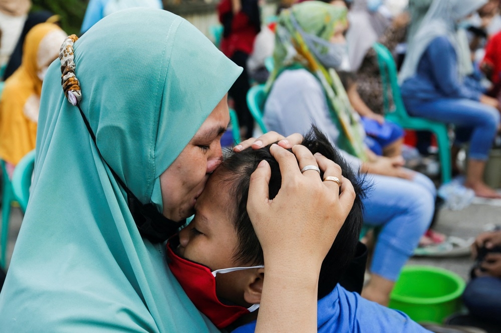 一名印尼母親於母親節親吻自己的孩子。示意圖。（湯森路透）