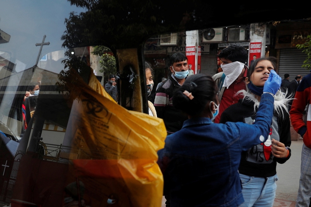 新德里防疫人員在街道替民眾進行快篩。（湯森路透）