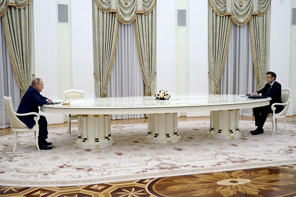 普京和馬卡洪會談時，中間隔著13英呎長桌。（湯森路透）