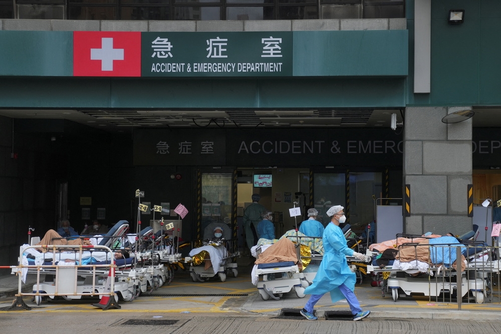 疫情升溫導致香港醫院病床極度不足，醫院被迫在急診外廣場，設置臨時隔離區安置患者。（湯森路透）