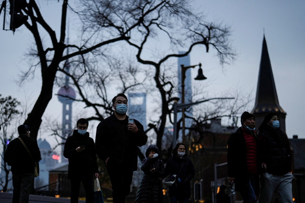 疫情仍有復甦的可能，上海市民外出依然戴上口罩防疫。（湯森路透）