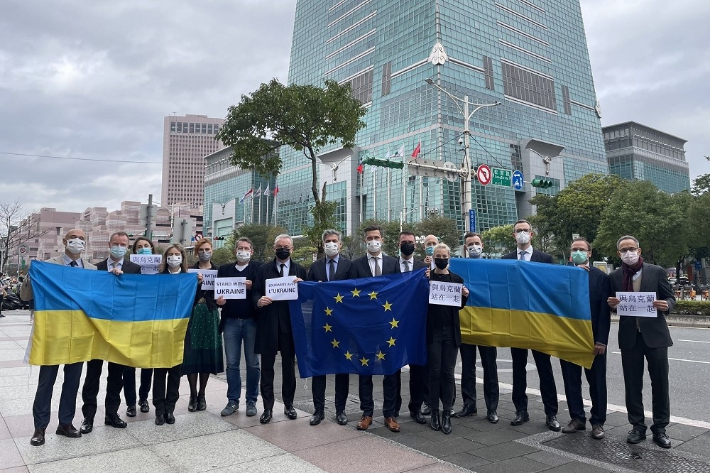 歐盟與會員國在台代表25日手持烏克蘭國旗及歐盟旗於台北101前聲挺。（取自Filip Grzegorzewski推特）