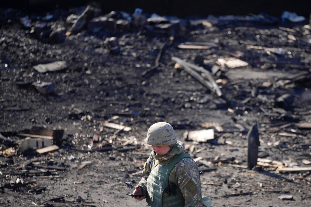 1名烏克蘭士兵走過遭俄軍空襲的基輔街區。（美聯社）