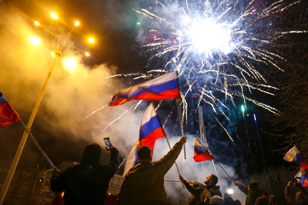 俄羅斯承認21日承認頓內次克共和國獨立，當地人揮舞俄羅斯國旗慶祝。（美聯社）