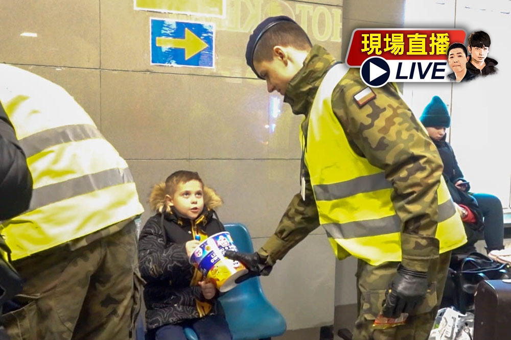 波蘭第九大城盧布林火車站內，波蘭軍人貼心地發糖果給剛逃出烏克蘭的小男孩。（沈粲家攝）