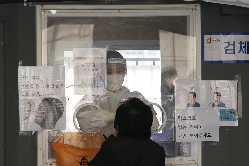 南韓防疫人員替民眾進行核酸檢測。（美聯社）