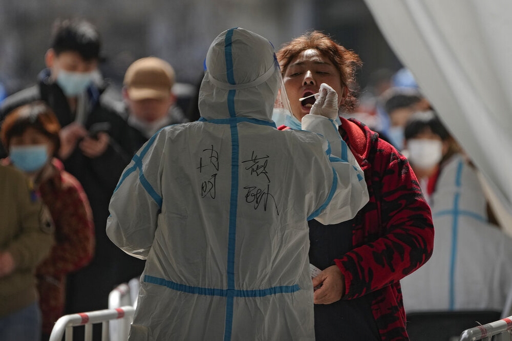 上海防疫人員替民眾進行快篩檢測。（美聯社）
