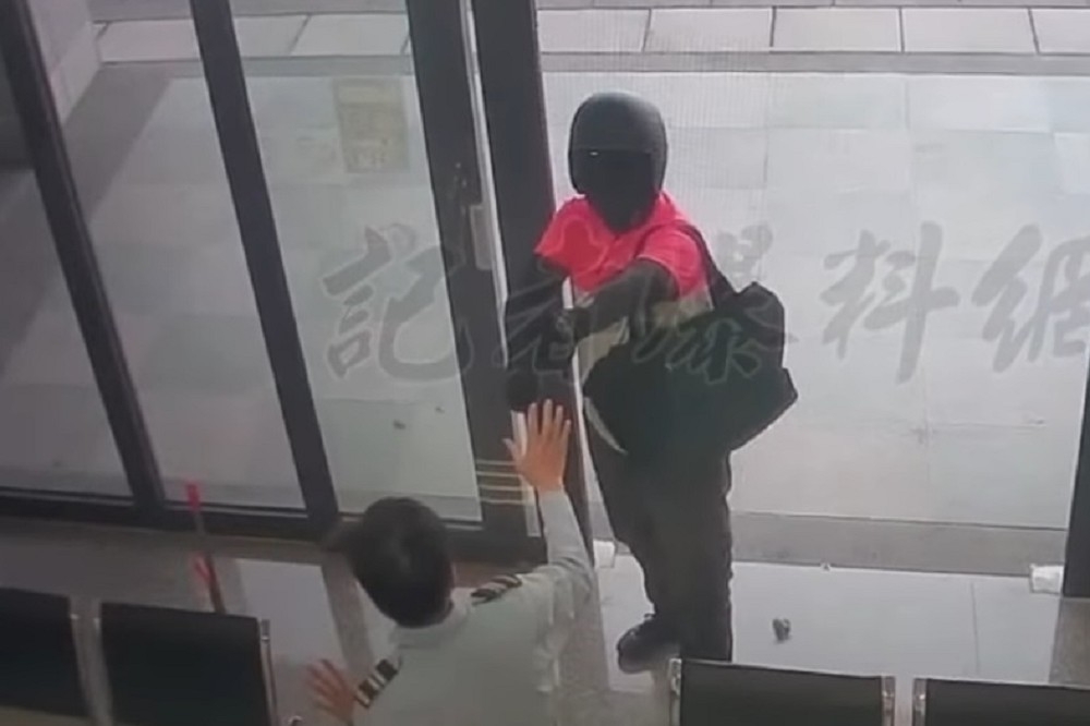 歹徒穿著foodpanda佯裝外送員，25日持槍行搶高雄三信商業銀行橋頭分行。（擷自記者爆料網臉書）