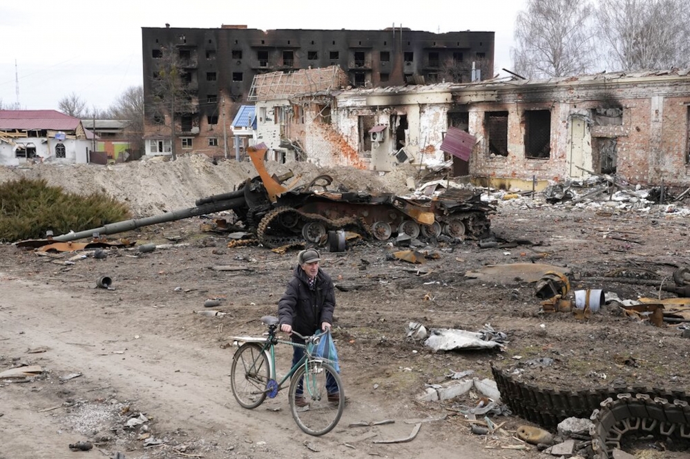 烏克蘭首都基輔東部郊區的特羅齊亞涅茲（Trostsyanets）鎮，一位居民行過全毀的建築和廢棄坦克車。（美聯社）