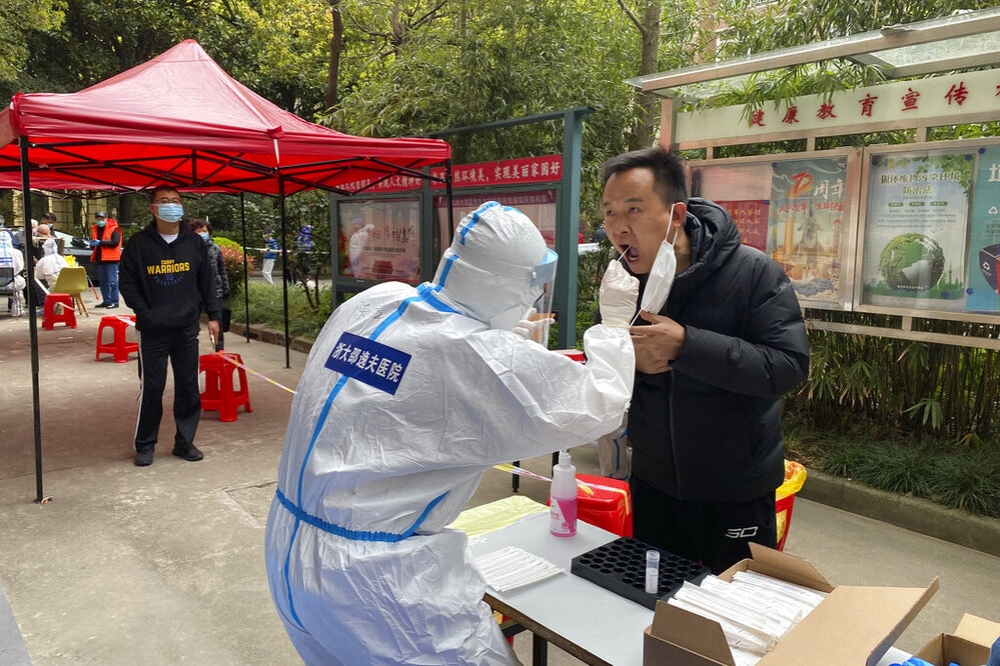 上海市防疫人員替社區居民進行核酸篩檢。（美聯社）