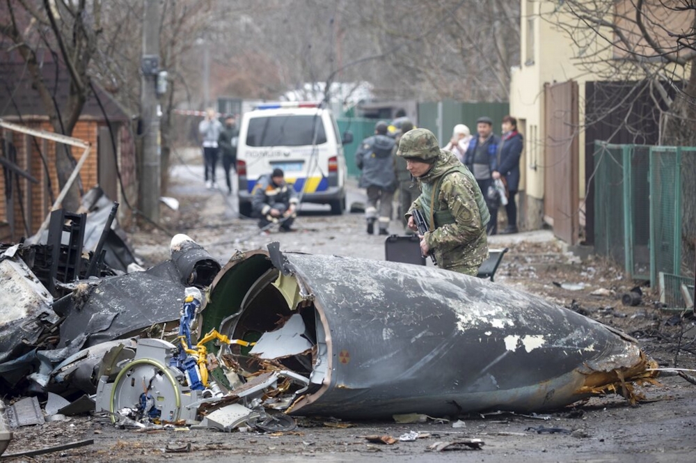 一名烏克蘭士兵正在查看墜毀戰機的殘骸，位於烏克蘭基輔。（美聯社）