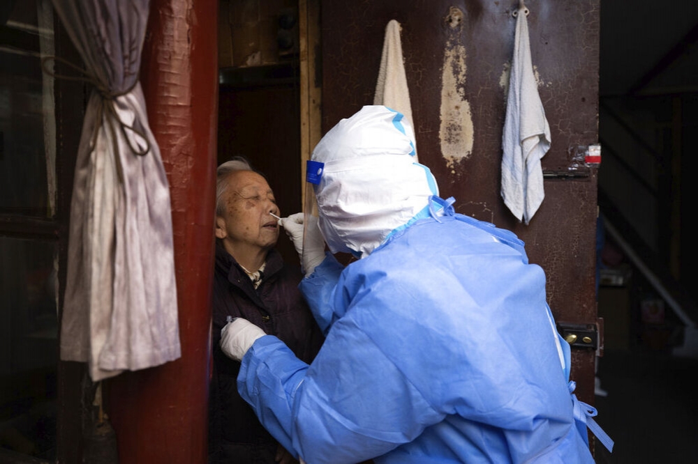 上海防疫人員替居民進行核酸篩檢。（美聯社）