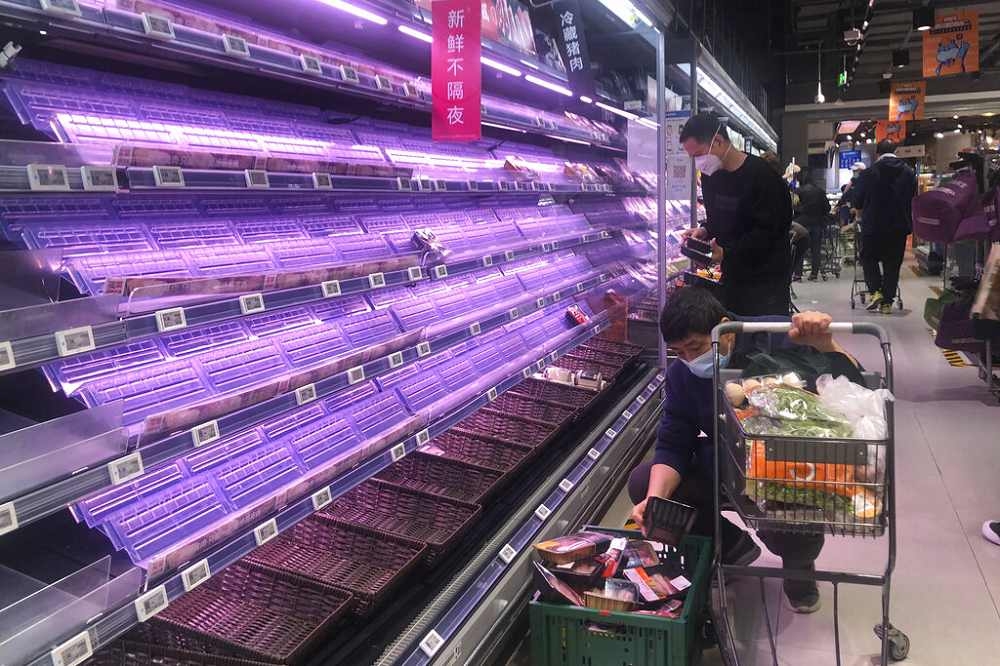 中國上海宣布封城後，超市貨架旋即被搶購一空，如今上海民眾陷入缺糧困境。（美聯社）