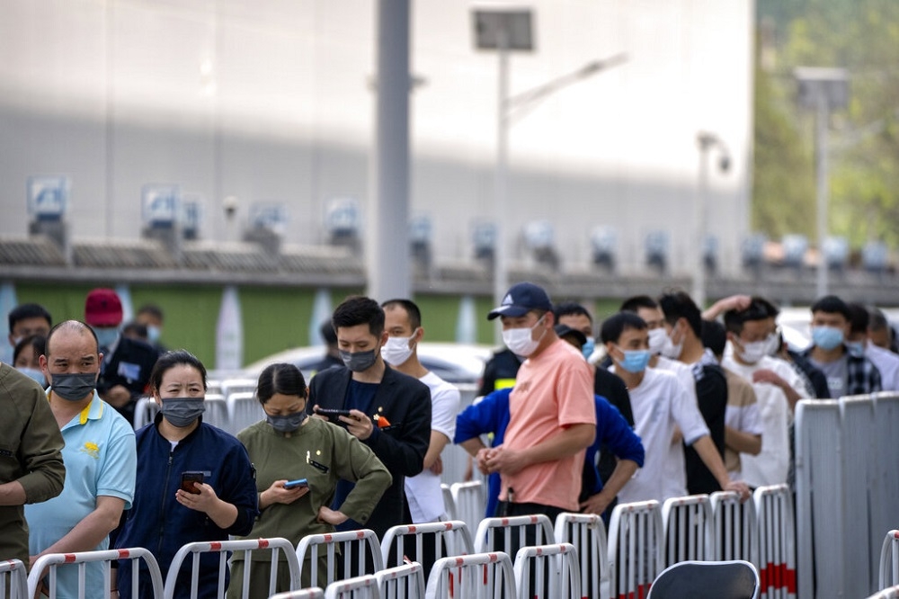 北京疫情亮紅燈，民眾排隊接受篩檢。（美聯社）