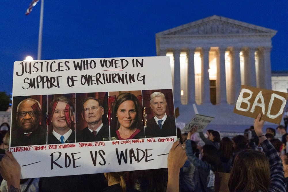 美國最高法院外集結抗議民眾， 海報列出有意推翻墮胎權的保守派大法官。（美聯社）