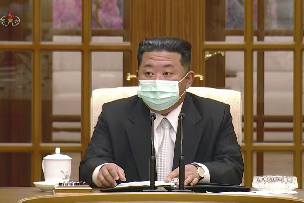 北韓領導人金正恩12日主持會議時載上口罩。（美聯社）