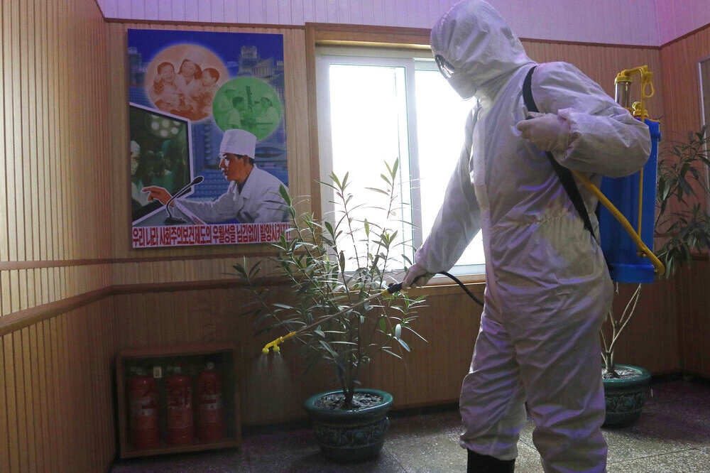 北韓平川一名防疫工作人員正在建築物內進行消毒。（美聯社）