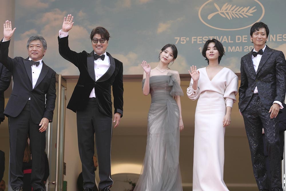 導演是枝裕和（左起）與演員宋康昊、IU、李周映與姜棟元合作的《嬰兒轉運站》再坎城影展首映，一起站在紅毯上接受粉絲的歡呼。（美聯社）