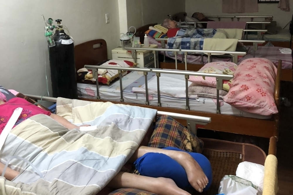 屏東縣東港鎮許姓男子照顧癱瘓母親多年，25日不知為何將母親推下樓。（新北市消防局提供）