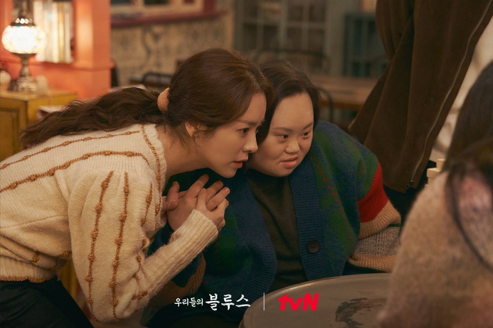 韓志旼在《我們的藍調時光》飾演神秘海女「英玉」，劇中有一個唐氏症雙胞胎姊姊，兩人戲外互動也超暖心。（取自tvN）