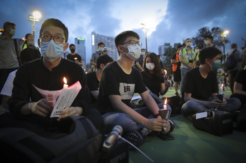 香港学运人士罗冠聪（左）、黄之锋（中）2020年出席维园悼念六四烛光晚会。（资料照片／美联社）(photo:UpMedia)